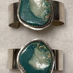 two sterling silver bracelets with large turquoise stones set in center