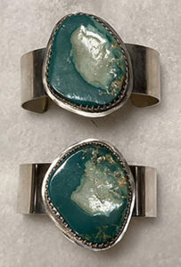 two sterling silver bracelets with large turquoise stones set in center